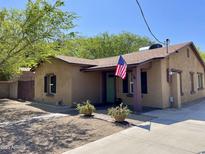 Charming single-story home with a cozy front porch, desert landscaping, and a welcoming American flag at 7226 N 31St Ave, Phoenix, AZ 85051