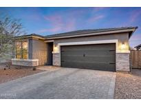 Charming single-story home with stone accents, a paver driveway, and a two-car garage creates a welcoming curb appeal at 738 W Kingman Dr, Casa Grande, AZ 85122