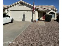 Charming single-story home featuring a tidy landscaped yard, two-car garage, and welcoming red front door at 8226 W Eugie Ave, Peoria, AZ 85381