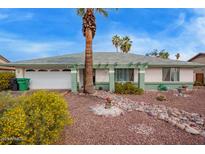 Charming single-story home featuring a lush, low-maintenance yard, palm trees, and a well-manicured lawn at 848 W Keating Ave, Mesa, AZ 85210