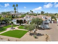 Expansive home showcasing manicured lawns, palm trees, and mountain views in the background at 10050 N 58Th St, Paradise Valley, AZ 85253
