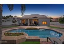 A private backyard featuring a refreshing pool with a brick surround and an outdoor dining space at 16428 N 39Th Pl, Phoenix, AZ 85032
