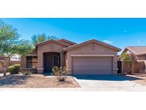 Charming single-story home featuring a two-car garage and low maintenance desert landscaping at 17633 W Wind Song Ave, Goodyear, AZ 85338