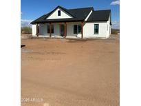 Charming single-story home featuring a white exterior, a dark roof, and a covered porch with wooden columns at 28003 N Faded Creek Dr, Florence, AZ 85132