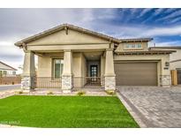 Stunning home featuring a welcoming front porch with stone accents and a well-manicured lawn at 5650 E Scarlet St, Mesa, AZ 85215