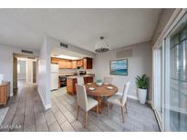 Cozy dining area with views of the kitchen with wood cabinets and stainless steel refrigerator at 10411 N 11Th Ave # 28, Phoenix, AZ 85021