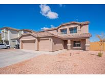 Charming two-story home featuring a tile roof, large garage, and a well-maintained gravel front yard at 1202 W Central Ave, Coolidge, AZ 85128