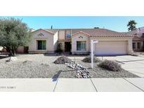 Inviting home exterior with desert landscaping, rock features, and a charming facade under a clear blue sky at 15273 N 92Nd Pl, Scottsdale, AZ 85260