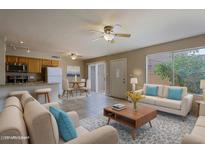 Bright living room with tile floors, ceiling fan, and open layout to the kitchen and dining area at 17031 E Calle Del Oro -- # B, Fountain Hills, AZ 85268