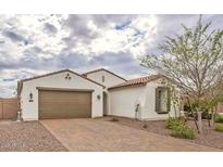 Charming single-story home features a brown two-car garage, terracotta roof, and a well-maintained brick driveway at 18385 W Devonshire Ave, Goodyear, AZ 85395