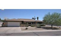 Traditional single-story home with a brick facade, two-car garage and mature landscaping at 2605 E Geneva Dr, Tempe, AZ 85282