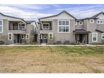 Charming townhome exterior with multiple levels, gray stucco, and a well-maintained lawn at 11300 N Casa Dega Dr # 1020, Surprise, AZ 85388