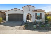 Charming single-story home featuring a well-manicured front yard, a tiled roof, and an arched gated front entry at 12047 E Sereno Rd, Gold Canyon, AZ 85118