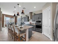 Elegant kitchen with gray cabinets, granite countertops, and a large central island at 12047 E Sereno Rd, Gold Canyon, AZ 85118
