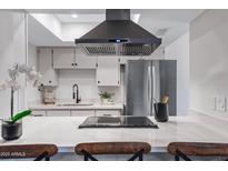 Modern kitchen featuring white cabinets, stainless steel appliances, and an island cooktop at 1455 N Alma School Rd # 38, Mesa, AZ 85201