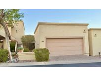 Beige house featuring a 2-car garage with mature landscaping, desert plants, and a tree at 16724 E Gunsight Dr # 118, Fountain Hills, AZ 85268