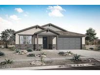 Charming single-story home with a neutral color scheme, desert landscaping, and a two-car garage, creating a welcoming curb appeal at 17310 W Via Dona Rd, Surprise, AZ 85387