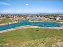 Scenic aerial view of a golf course community with lush greenery and a beautiful blue pond at 4538 E Shomi St, Phoenix, AZ 85044