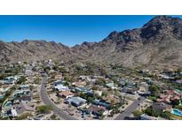Expansive aerial view of a neighborhood nestled against the backdrop of a majestic mountain range and clear blue sky at 7607 N 22Nd Pl, Phoenix, AZ 85020