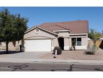 Charming single-story home featuring a two-car garage and low maintenance desert landscaping at 13480 W Canyon Creek Dr, Surprise, AZ 85374