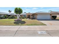 Charming home featuring a well-manicured lawn, mature trees, and an attached two-car garage, creating a welcoming curb appeal at 13620 N Hawthorn Dr, Sun City, AZ 85351