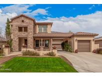 Beautiful two-story home with a lush front lawn, a stone facade, and a spacious three-car garage at 15322 W Montecito Ave, Goodyear, AZ 85395