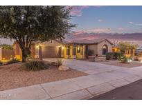 Charming single-story home with desert landscaping, tile roof, and two-car garage at dusk at 15881 W Berkeley Rd, Goodyear, AZ 85395