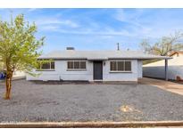 Charming single-story home featuring a gravel front yard and a covered carport for convenient parking at 1747 W Belfast St, Mesa, AZ 85201