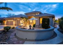 Charming exterior featuring a quaint patio with seating and desert landscaping at twilight at 17642 N Ironhorse Dr, Surprise, AZ 85374
