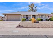 Charming single-story home featuring a well-manicured yard, neutral tones, and an attached two-car garage at 18402 N 94Th Dr, Sun City, AZ 85373