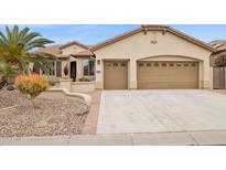 Beautiful home featuring a three-car garage, desert landscaping, and a well-maintained front yard at 2634 N 164Th Ave, Goodyear, AZ 85395