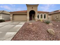 Charming single-story home showcasing a red-tiled roof, desert landscaping, and an attached two-car garage at 42618 W Oakland Dr, Maricopa, AZ 85138