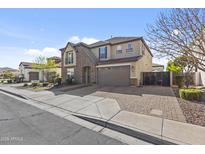 Front view of a two-story house with a stone facade, two-car garage and a small balcony at 4321 E Zion Way, Chandler, AZ 85249