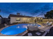 Inviting backyard pool with stone accents and ample space for lounging, perfect for relaxation and entertaining at 4826 W Michigan Ave, Glendale, AZ 85308