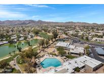 Scenic aerial view of the community showcasing the pool, golf course, and mountain views against a bright, blue sky at 12007 S Crow Ct, Phoenix, AZ 85044