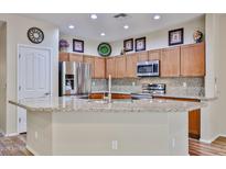 Bright kitchen features stainless appliances, granite counters, and light wood cabinetry at 17062 N 184Th Dr, Surprise, AZ 85374
