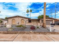 Charming single-story brick home with desert landscaping, two palm trees, and a two-car garage at 2602 W Summit Pl, Chandler, AZ 85224