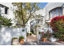 Inviting front entrance with lush landscaping, bougainvillea, and white stucco walls at 4955 E Indian School Rd # 5, Phoenix, AZ 85018