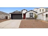 Inviting single-story home featuring a two-car garage, red door, and low maintenance desert landscaping at 7414 W Whitehorn Trl, Peoria, AZ 85383