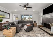 Bright living room with a corner fireplace, large gray sofa, and lots of natural light from the window at 8345 E Oak St, Scottsdale, AZ 85257