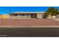 Charming single story home featuring a low maintenance desert rock yard and neutral brick facade at 1002 W Fairway Dr, Mesa, AZ 85201