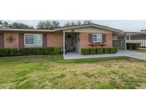 Charming single-story brick home with manicured landscaping and cozy curb appeal at 10417 W Deanne Dr, Sun City, AZ 85351