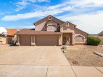 Charming two-story home featuring a three-car garage and low-maintenance desert landscaping at 14317 N 78Th Dr, Peoria, AZ 85381