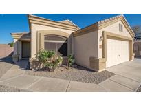 Beige single-story home featuring a two car garage, desert landscaping, and concrete walkway at 14717 N 130Th Ln, El Mirage, AZ 85335