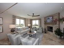 Cozy living room features a stone fireplace, tile flooring, and bright windows with natural light at 15802 N 71St St # 501, Scottsdale, AZ 85254