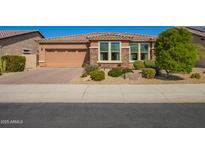 Charming single-story home featuring a two-car garage, stone accents, desert landscaping, and a tile roof at 18118 W Redwood Ln, Goodyear, AZ 85338