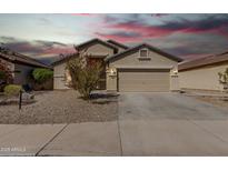 Charming single-story home featuring a well-manicured front yard, a spacious driveway, and a welcoming two-car garage at 24824 W Pueblo Ave, Buckeye, AZ 85326