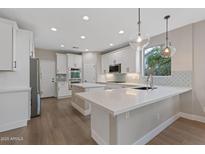 Bright kitchen featuring white cabinets, dual islands and modern stainless steel appliances at 3393 E Fandango Dr, Gilbert, AZ 85298