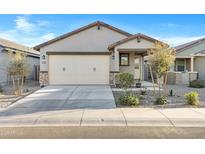 Charming single-story home featuring a two-car garage and desert landscaping in front yard at 40005 W Rio Lobo Dr, Maricopa, AZ 85138