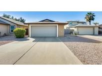 Charming single-story home with a gray garage door, low maintenance rock landscaping and private front courtyard at 4343 E Contessa St, Mesa, AZ 85205